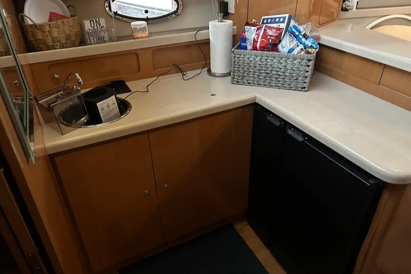 Slide: The Image of Compact kitchen area in a 2001 Regal Commodore 3780 yacht with sink and storage. - 4