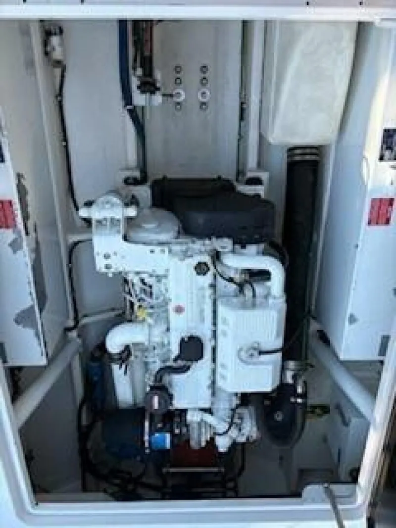 Slide: The Image of A clean engine compartment with a large engine, surrounded by white walls and hoses. - 14