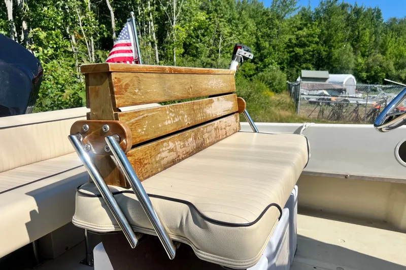 Slide: The Image of 1973 Boston Whaler 19 OUTRAGE boat interior with wooden bench and American flag. - 17