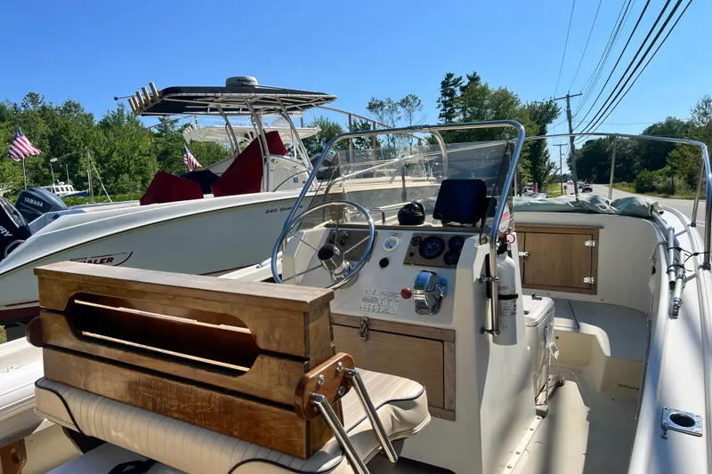 Slide: The Image of 1973 Boston Whaler 19 Outrage boat interior with steering wheel and dashboard, sunny day. - 14