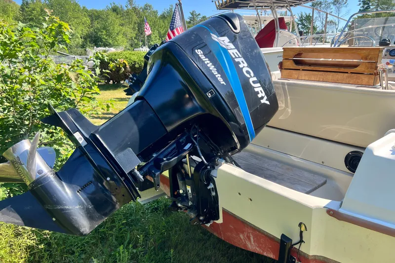 Slide: The Image of 1973 Boston Whaler 19 Outrage with Mercury outboard motor in a sunny outdoor setting. - 12