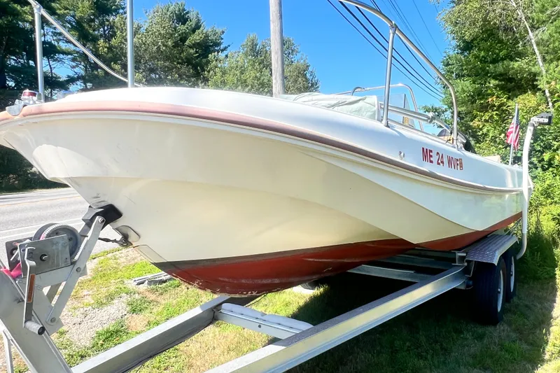 Slide: The Image of 1973 Boston Whaler 19 Outrage boat on trailer, parked outdoors with trees in background. - 5