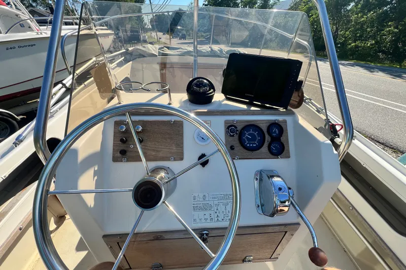 Slide: The Image of 1973 Boston Whaler 19 Outrage boat dashboard with steering wheel and navigation instruments. - 4