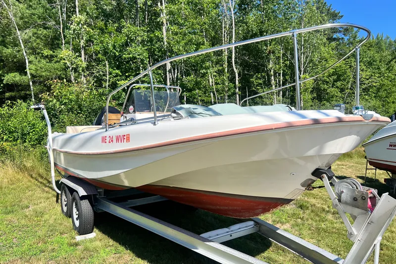 Slide: The Image of 1973 Boston Whaler 19 Outrage boat on trailer, surrounded by lush greenery. - 6