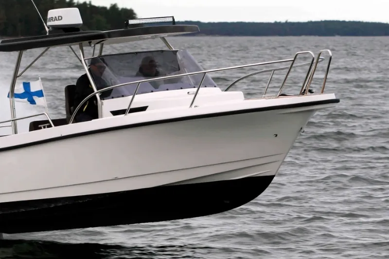 The Image of 2021 Nord Star 25 HT Sport boat cruising on a lake with Finnish flag. - 1