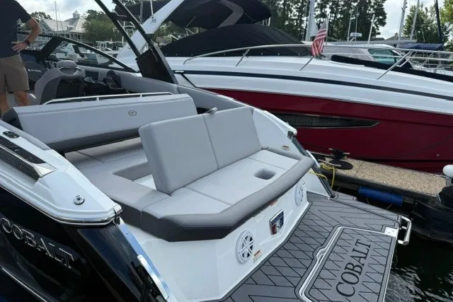 Slide: The Image of 2024 Cobalt R8 boat with sleek seating and modern design at a marina. - 30