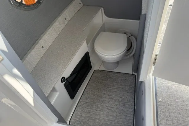 Slide: The Image of 2024 Cobalt R8 boat interior bathroom with toilet and storage area. - 19