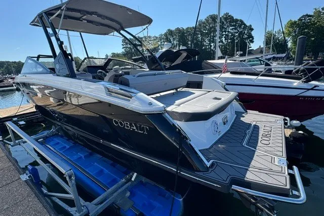 Slide: The Image of 2024 Cobalt R8 boat docked, showcasing sleek design and spacious seating. - 2