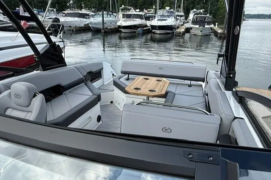Slide: The Image of 2024 Cobalt R8 boat interior with seating and table, docked at a marina. - 6