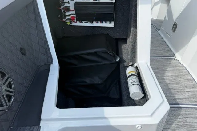 Slide: The Image of 2024 Cobalt R8 boat storage compartment with speaker and fire extinguisher. - 43