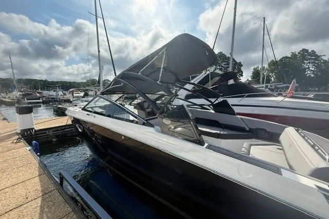 Slide: The Image of 2024 Cobalt R8 boat docked at marina under cloudy sky. - 32
