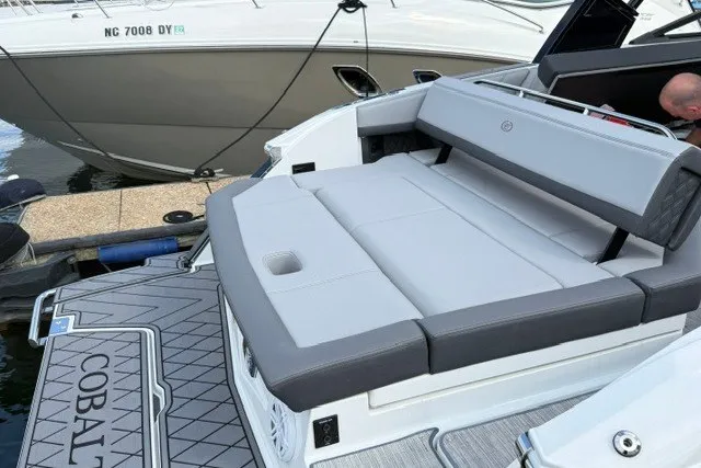 Slide: The Image of 2024 Cobalt R8 boat with luxurious seating and sleek design at a marina. - 29