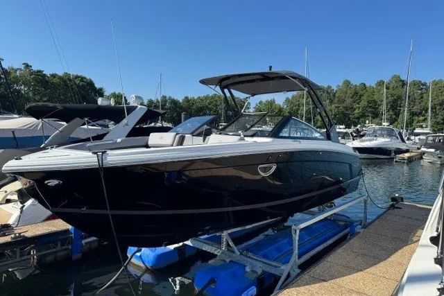 Slide: The Image of 2024 Cobalt R8 boat docked at marina under clear blue sky. - 1