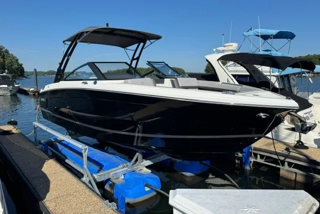The Image of 2024 Cobalt R8 boat docked at marina, featuring sleek black design and modern canopy. - 0