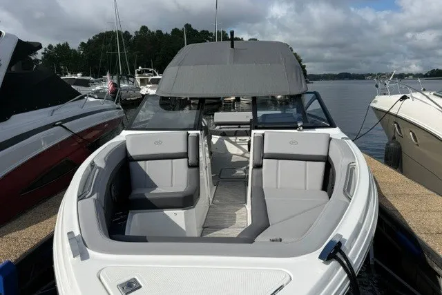 Slide: The Image of 2024 Cobalt R8 boat docked, featuring sleek design and spacious seating on a calm lake. - 34