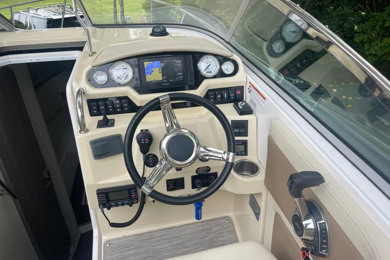 Slide: The Image of 2019 Regal 28 Express boat dashboard with steering wheel and navigation controls. - 26