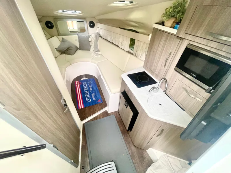 Slide: The Image of Interior of 2019 Regal 28 Express boat with kitchenette and seating area. - 4