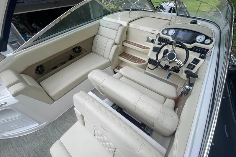 Slide: The Image of 2019 Regal 28 Express boat interior with beige seating and modern dashboard controls. - 16