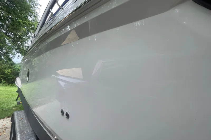 Slide: The Image of 2019 Regal 28 Express boat side view, showcasing sleek design and glossy finish. - 44