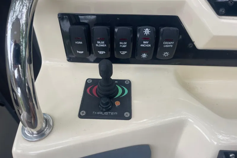 Slide: The Image of Control panel of a 2019 Regal 28 Express boat with switches and thruster joystick. - 28