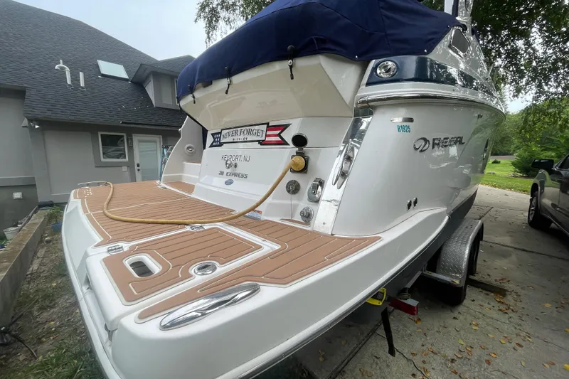 Slide: The Image of 2019 Regal 28 Express boat on trailer, parked near a house. - 45