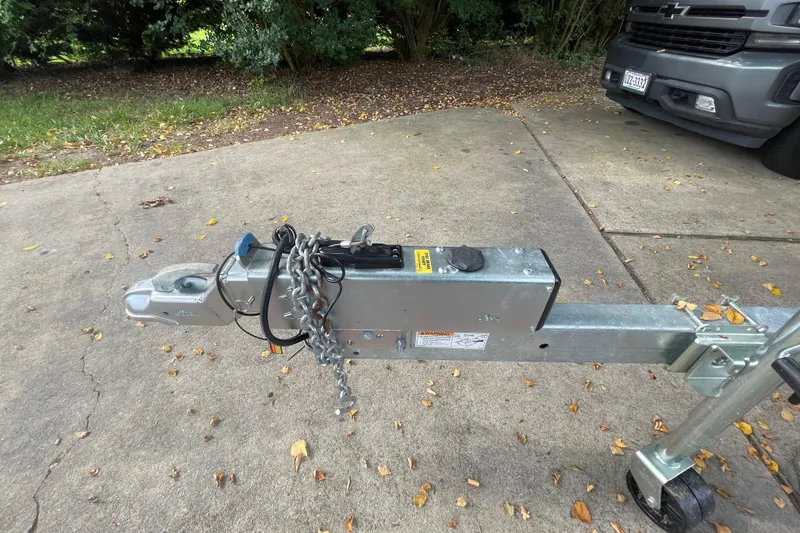 Slide: The Image of Trailer hitch of a 2019 Regal 28 Express on a concrete driveway. - 48