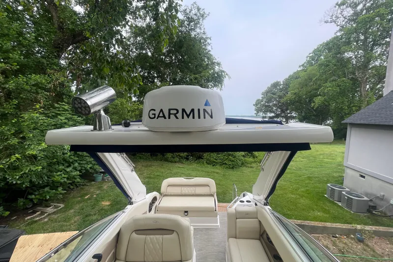 Slide: The Image of 2019 Regal 28 Express boat with Garmin radar, surrounded by lush greenery. - 22