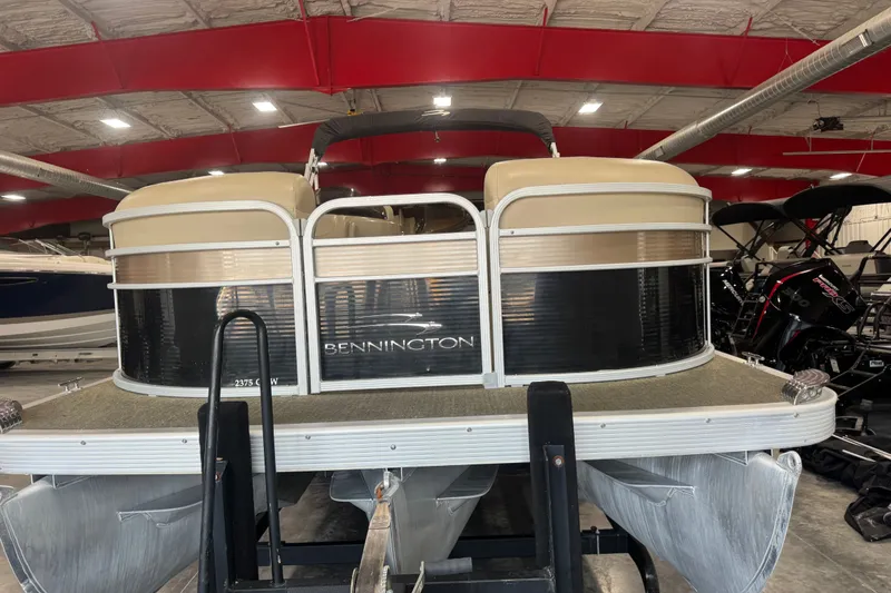 Slide: The Image of 2013 Bennington 2375 GCW pontoon boat in a showroom, featuring sleek design and modern amenities. - 5