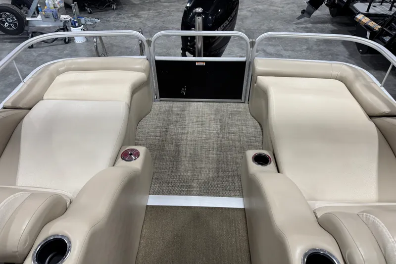 Slide: The Image of 2013 Bennington 2375 GCW pontoon boat interior with beige seating and cup holders. - 12