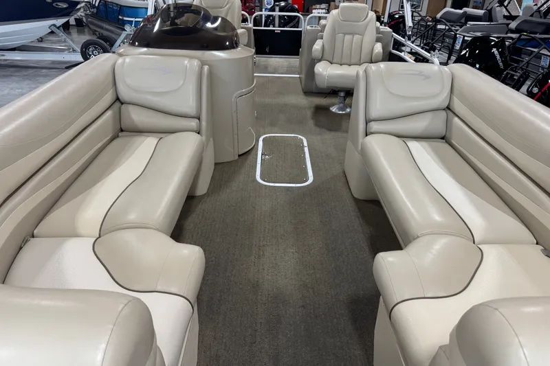 Slide: The Image of 2013 Bennington 2375 GCW pontoon boat interior with beige seating and carpeted floor. - 8