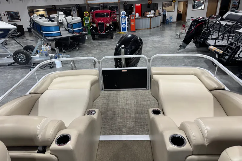 Slide: The Image of 2013 Bennington 2375 GCW pontoon boat interior with beige seating in showroom. - 9
