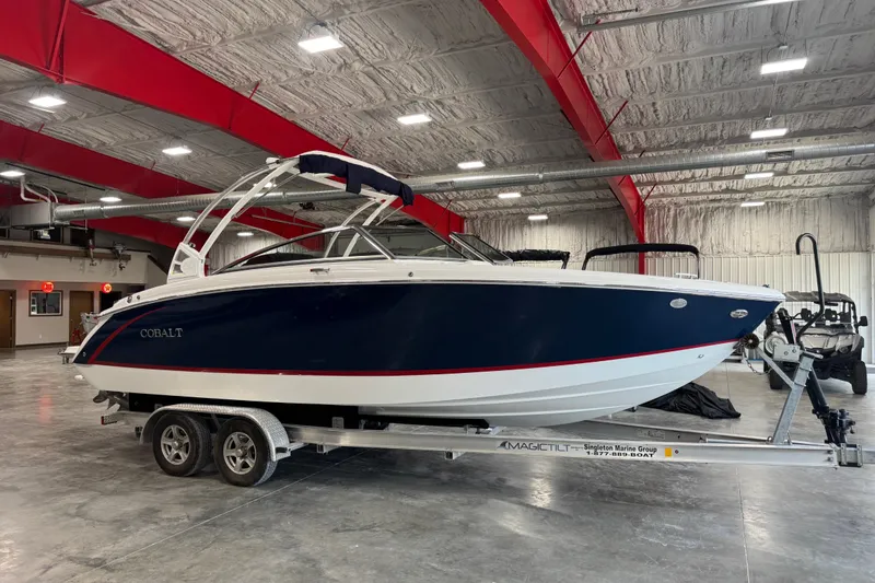 The Image of 2020 Cobalt R5 boat on trailer in indoor showroom with red ceiling beams. - 1