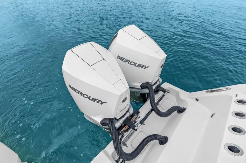 Slide: The Image of Twin Mercury outboard engines on a 2023 Freeman 37 boat, floating on clear blue water. - 31