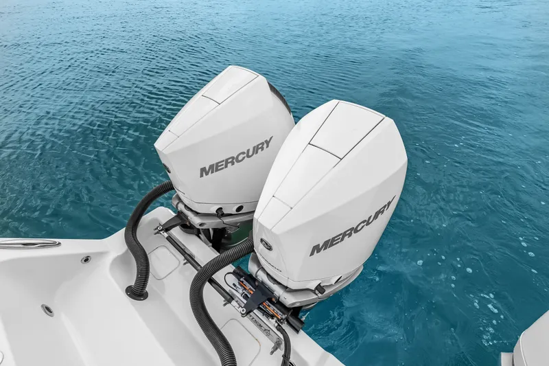 Slide: The Image of Twin Mercury outboard engines on a 2023 Freeman 37 boat in clear blue water. - 32