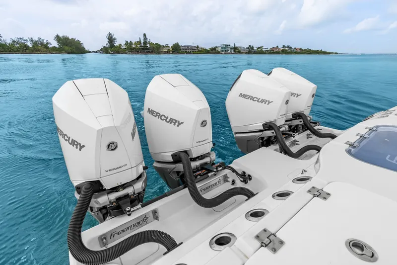 Slide: The Image of Four Mercury Verado outboard engines on a 2023 Freeman 37 boat in clear blue water. - 30