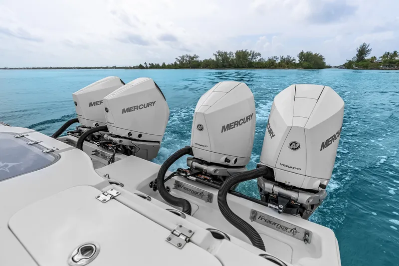 Slide: The Image of Four Mercury outboard engines on a 2023 Freeman 37 boat in clear blue waters. - 29