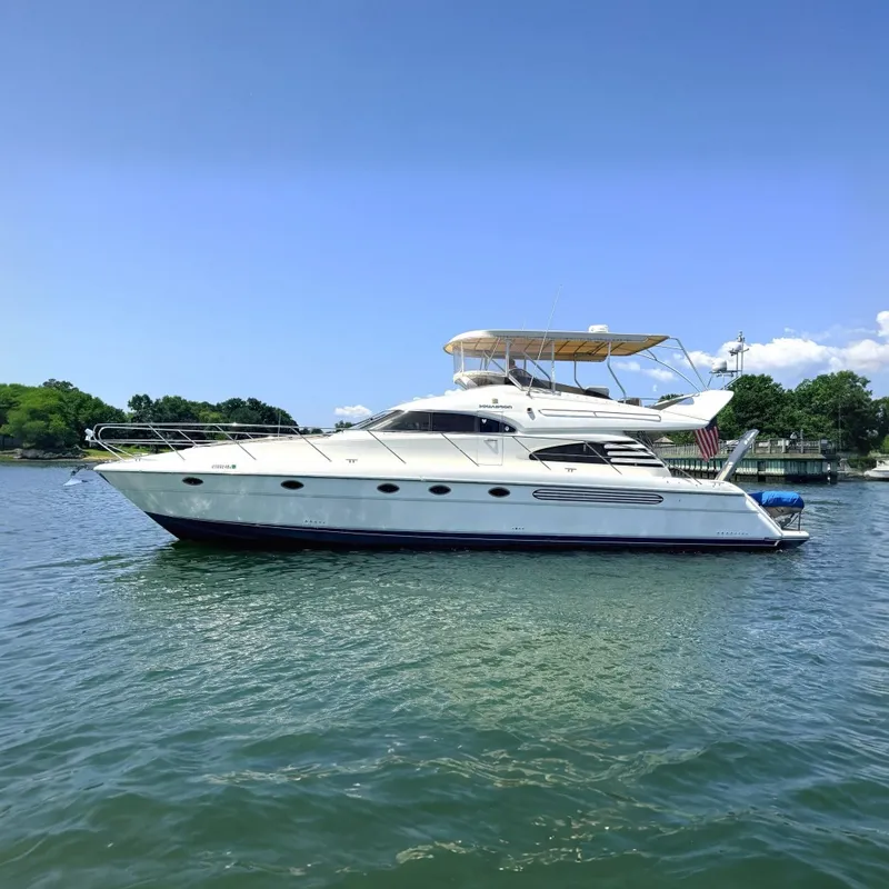 The Image of A 2000 Fairline Squadron 55 on calm water. It features sleek design and a flybridge. - 0