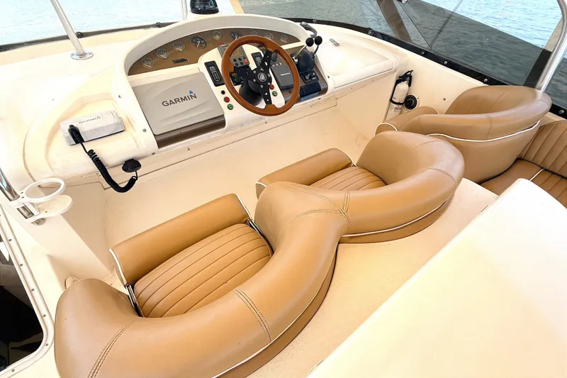 Slide: The Image of The image shows the cockpit of a 2000 Fairline Squadron 55 with beige leather seats. - 19