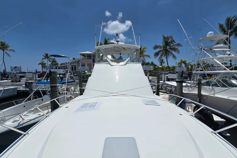 Slide: The Image of 2005 Cavileer 44 Convertible yacht docked at marina with palm trees and clear sky. - 38