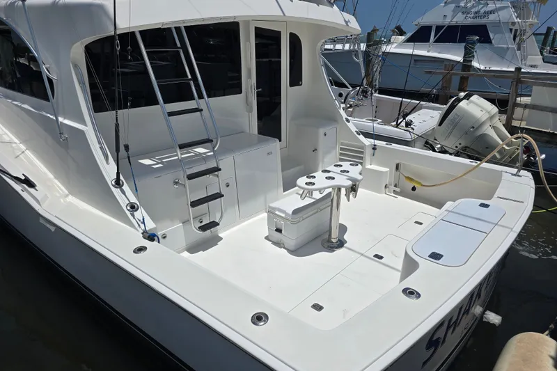 Slide: The Image of 2005 Cavileer 44 Convertible yacht docked, featuring spacious deck and fishing equipment. - 7