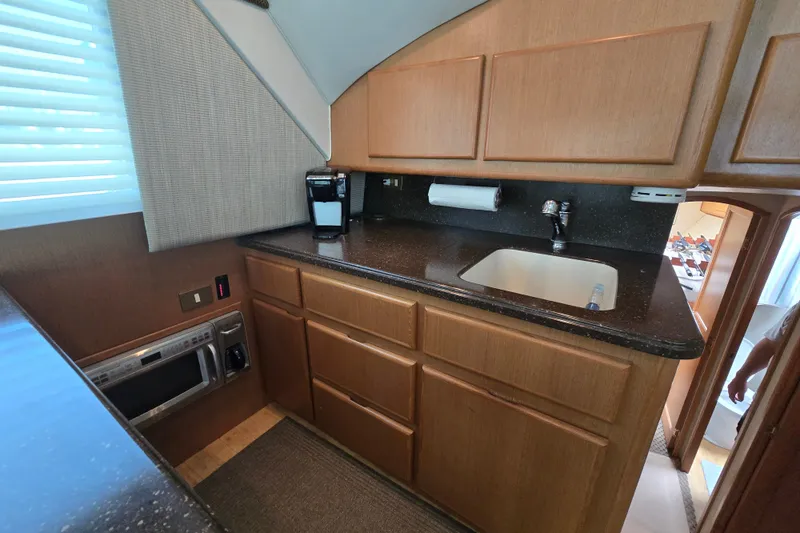 Slide: The Image of 2005 Cavileer 44 Convertible yacht kitchen with wood cabinets and modern appliances. - 20