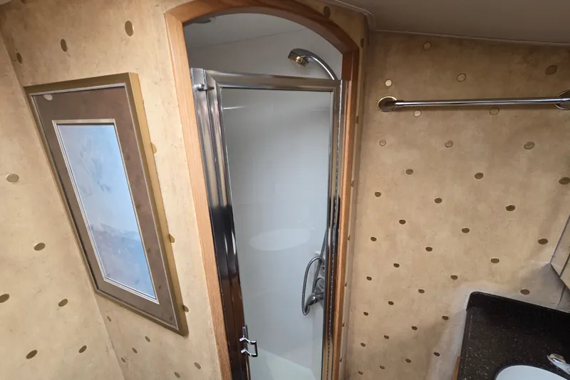 Slide: The Image of Bathroom interior of 2005 Cavileer 44 Convertible yacht with shower and decorative wall art. - 24