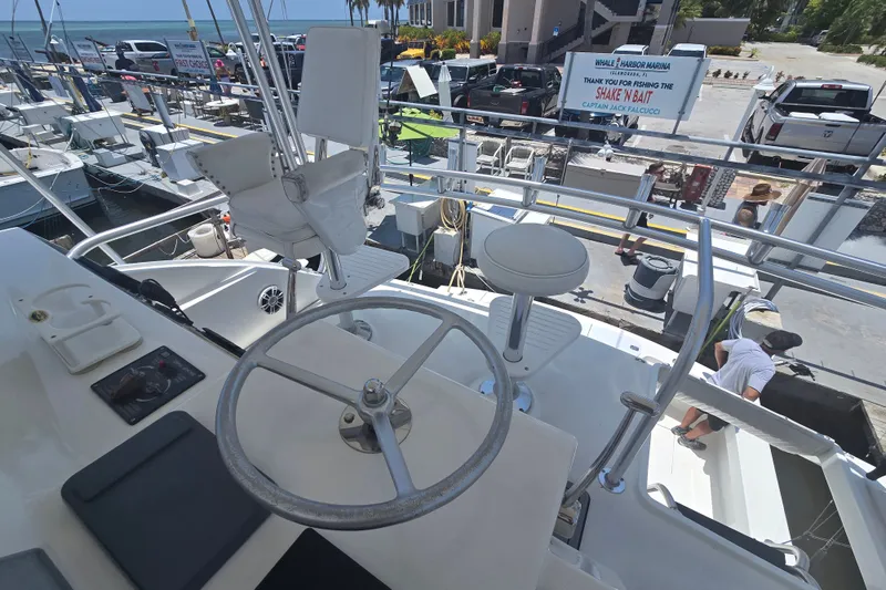 Slide: The Image of 2005 Cavileer 44 Convertible yacht at marina, featuring helm and seating area. - 13