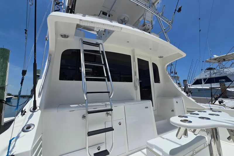 Slide: The Image of 2005 Cavileer 44 Convertible yacht with ladder and fishing rod holders, docked at marina. - 37