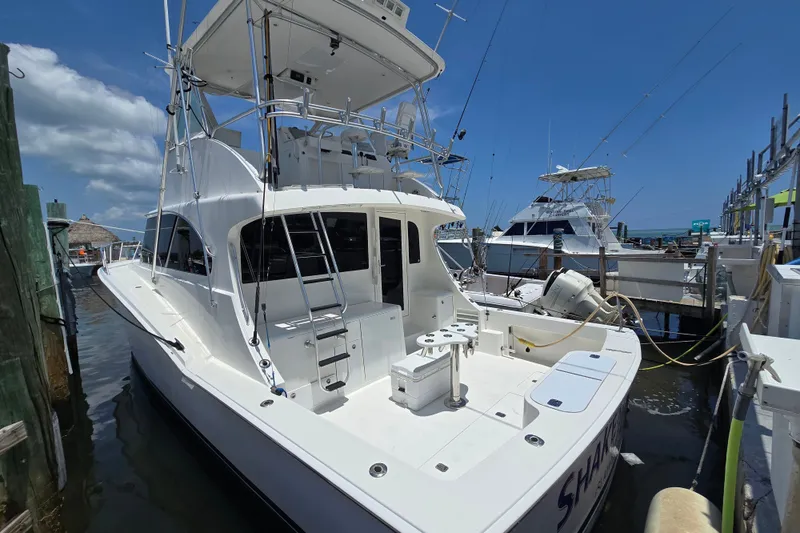 Slide: The Image of 2005 Cavileer 44 Convertible yacht docked at marina under clear blue sky. - 8