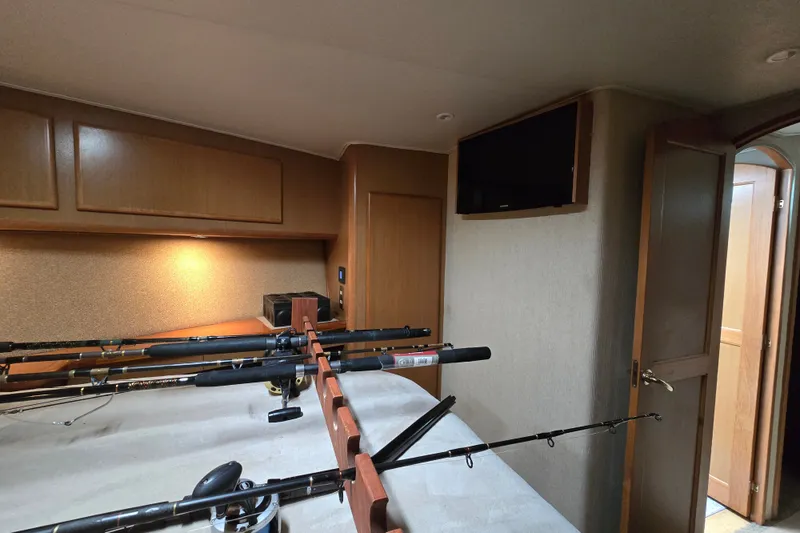 Slide: The Image of Interior of 2005 Cavileer 44 Convertible with fishing rods and wooden cabinetry. - 32