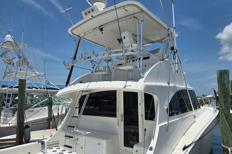 Slide: The Image of 2005 Cavileer 44 Convertible yacht docked at marina under clear blue sky. - 5