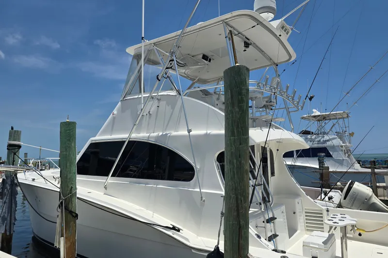 Slide: The Image of 2005 Cavileer 44 Convertible yacht docked at marina under clear blue sky. - 2