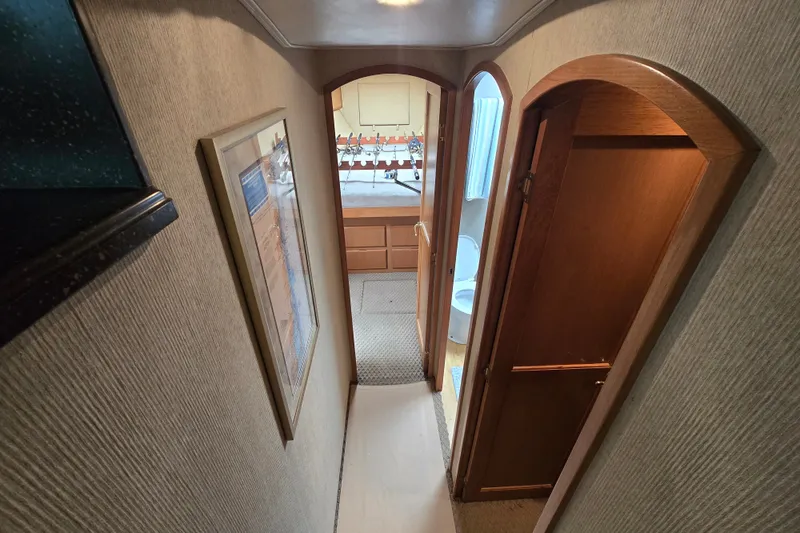 Slide: The Image of Interior hallway of 2005 Cavileer 44 Convertible yacht with wooden doors and framed artwork. - 30