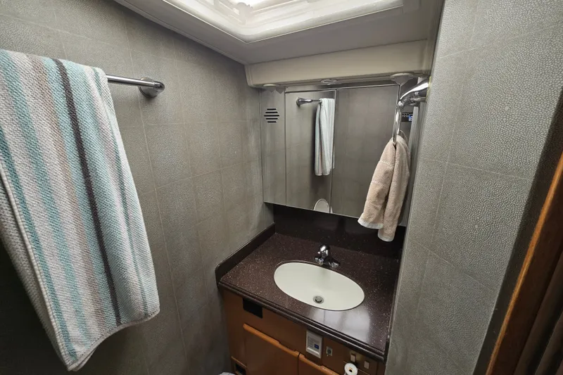 Slide: The Image of Compact bathroom in a 2005 Cavileer 44 Convertible yacht with towels and sink. - 26